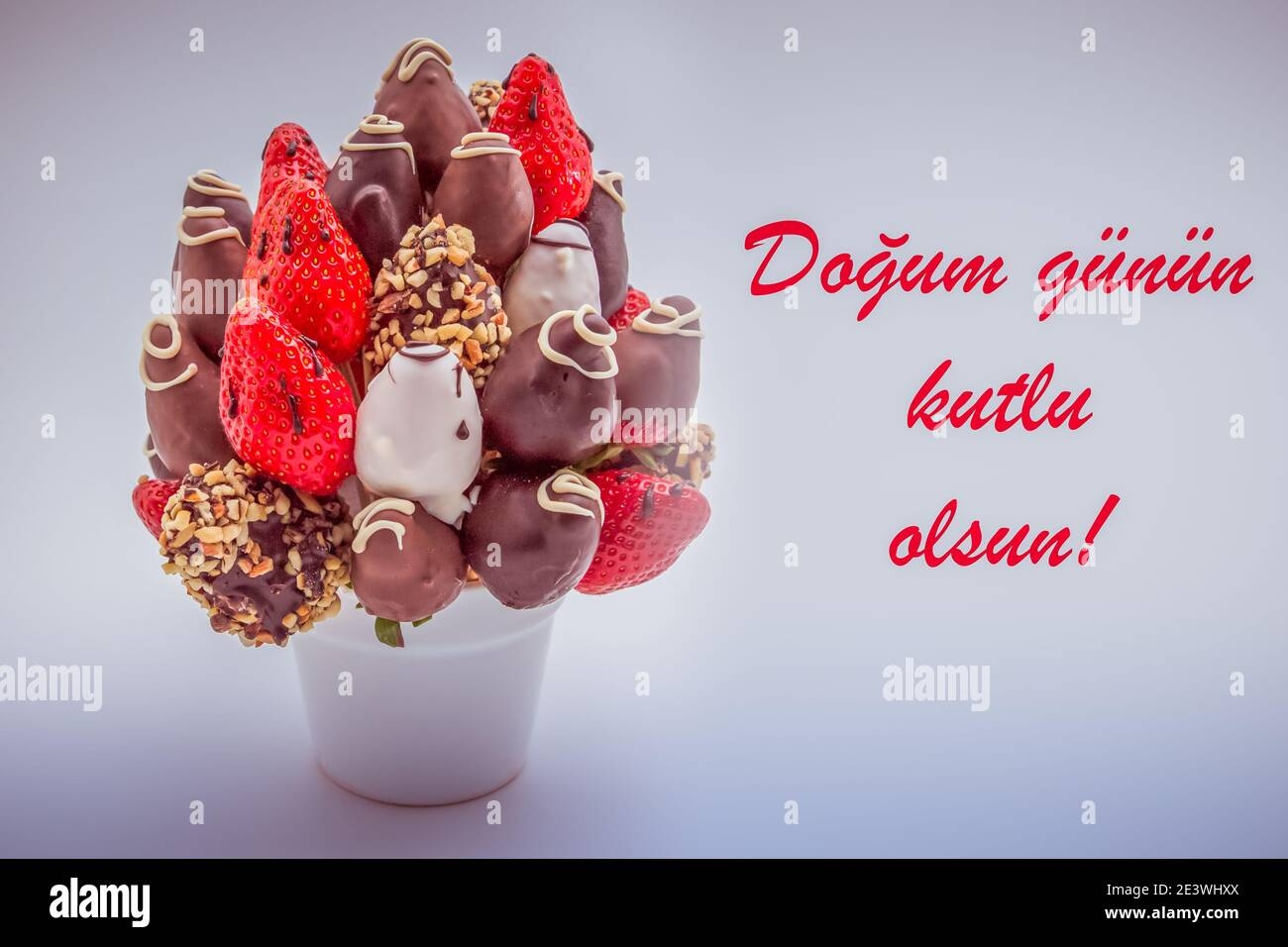 Happy Birthday Greeting Card In Turkish Language With Red Lettering That Reads Dogum Gunun Kutlu Olsun A Bunch Of Edible Flowers Arrangement Of Choc Stock Photo Alamy